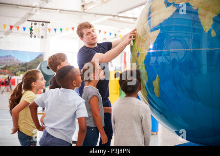 Kinder beobachten Präsentation mit riesigen Globus zu einem Science Center Stockfoto