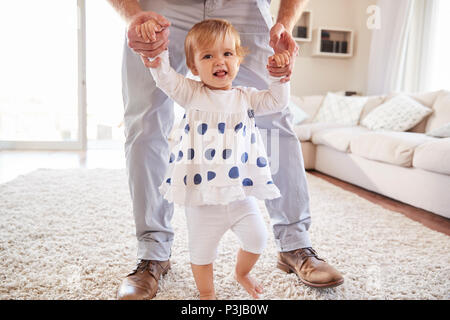 Vater, Tochter erfahren Sie im Wohnzimmer zu gehen Stockfoto