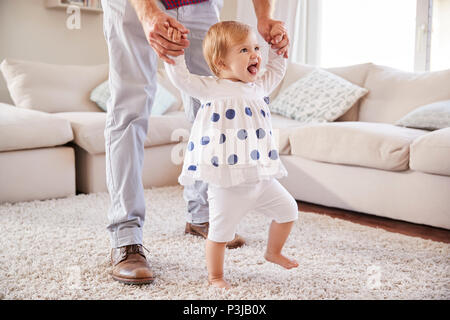 Vater, Tochter erfahren Sie im Wohnzimmer zu gehen Stockfoto