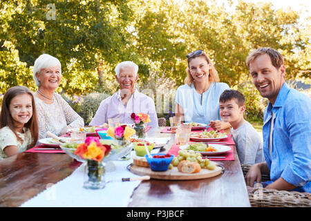 Drei Generationen der Familie beim Mittagessen im Garten Stockfoto