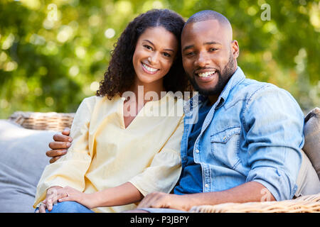 Glückliche junge schwarz Paar sitzen und in den Garten Stockfoto