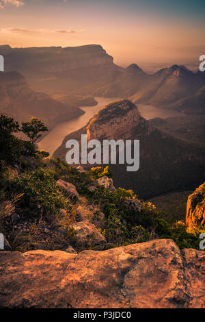 Portraitfotos der Blyde River Canyon gebadet in verträumten in warmen Rosa- und Apfelsinen, die während Pre - Sonnenuntergang goldenen Stunde. Vordergrund Rock. Mpumalanga, Südafrika Stockfoto