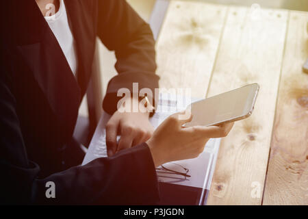 Close up Business woman Sie Ihr Smartphone während der Sitzung entspannen im Coffee Shop. Konzept der Business Leute, die mobile Geräte. Nahaufnahme mit einem SELE Stockfoto