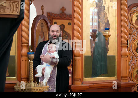 Belarus, Gomel, 24. Februar 2018. Kirche der Birken. Die Taufe eines Kindes. Stockfoto