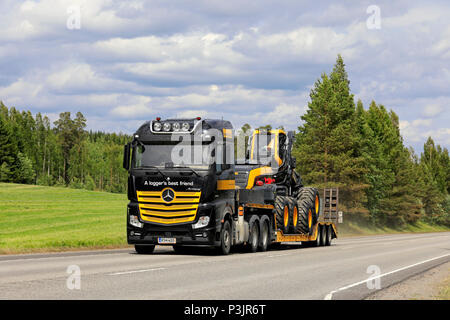 Mercedes-Benz Actros 3363 halb von Ponsse Plc in Schwarz und Gelb Transporte Scorpion Wald Harvester im Sommer. Uurainen, Finnland - 15. Juni 2018. Stockfoto