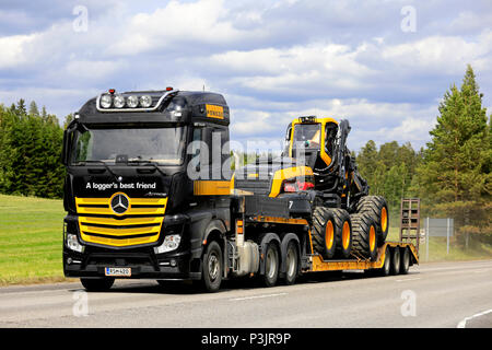 Mercedes-Benz Actros 3363 semi in Ponsse Plc Farben Schwarz und Gelb Transporte Scorpion Wald Harvester im Sommer. Uurainen, Finnland - 15. Juni, 2018 Stockfoto