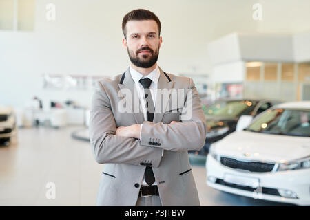 Reifen Geschäftsmann posiert in Autohaus Stockfoto