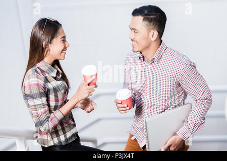 Junger Mann und Frau sprechen, während Kaffee trinken während der Pause Stockfoto