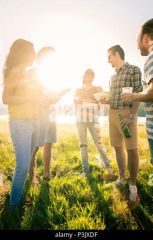 Eine Gruppe von Freunden im Kreis stehend auf Grillparty Stockfoto