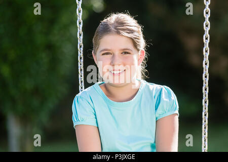 Kid in swingtime am Abenteuerspielplatz Stockfoto