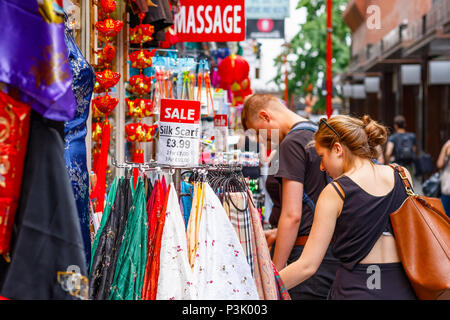 London, UK - Juli 01, 2018 - Touristen surfen außerhalb einer Kleidung und Souvenir Shop in Chinatown Stockfoto