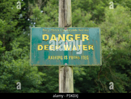 Gefahr Tiefwasserschild mit grünem Hintergrund, gelber Schriftzug abblätternder, montiert auf Holzmast im Burrs Country Park Bury lancashire uk Stockfoto