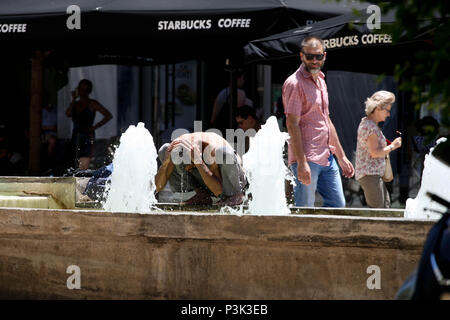 Ein obdachloser Mann einen Brunnen in der Mitte von Athen. Stockfoto