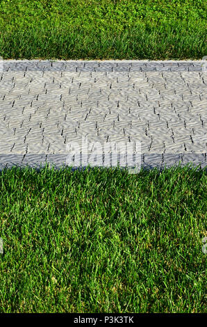 Ein schöner neuer Gehweg aus Stein befindet sich in den grünen Gras entfernt Stockfoto