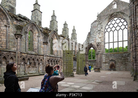 Tourist, Foto in den Ruinen des 12. Jahrhunderts Holyrood Abbey, der Holyrood Palace, Altstadt von Edinburgh Stockfoto