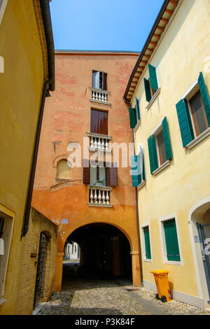 Eine Gasse mit Kopfsteinpflaster im Zentrum der Stadt Treviso. Ein Mülleimer ist das einzige Anzeichen von Leben während der Siesta im heißen Sommer. Stockfoto