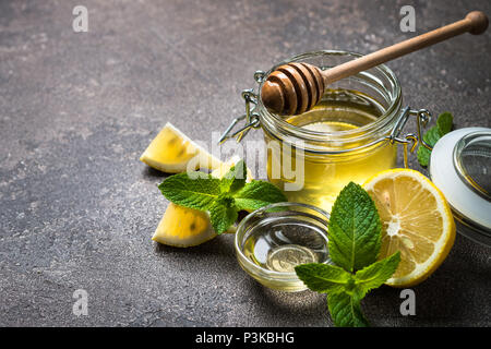 Honig in einem Glas mit Zitrone und Minze. Stockfoto