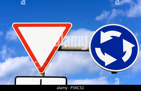 Zwei Verkehrsschilder vor einem blauen Himmel mit weißen Wolken, in der Nähe Stockfoto