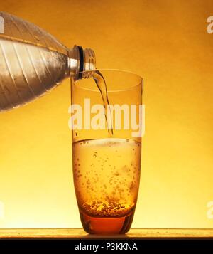 In einem Glas mit kaltem Mineralwasser aus Plastikflaschen gefüllt. Still-Leben. Stockfoto