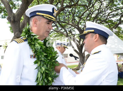 Hintere Adm. Vincent Atkins, Commander für die Küstenwache 14. Bezirk, stellt eine Auszeichnung an Kapitän Shannon Gilreath während einer Küstenwache Sektor Honolulu Ändern des Befehls Zeremonie an der Coast Guard Base Honolulu, 1. Juli 2016. Die Änderung des Befehls Zeremonie ist eine altehrwürdige Tradition, die formell Transfers Zuständigkeit, Befugnis und Verantwortlichkeit von einem Individuum auf ein anderes. (U.S. Coast Guard Foto von Petty Officer 2. Klasse Tara Molle/Freigegeben) Stockfoto