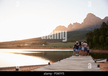 Ansicht der Rückseite des Multi Generation Familie stehend auf Steg am See Stockfoto