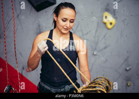 Kletterer Mädchen in Sicherheit Kabelbaum binden Seil in acht Knoten und Vorbereitung zu klettern, Blick auf die Hände Stockfoto