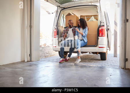Paar eine Pause in der Rückseite der Ausbau Lkw am Umzugstag Stockfoto