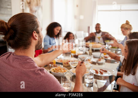 Zwei Familien genießen Mahlzeit zu Hause zusammen Stockfoto