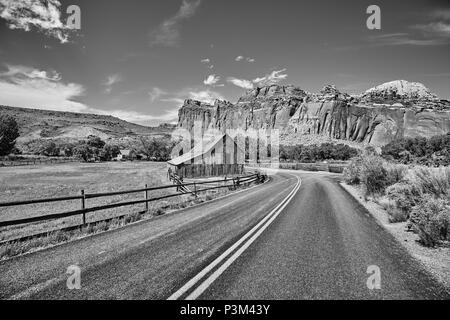 Schwarz-weiß Bild der Gifford Scheune durch eine Straße im Capitol Reef National Park, Utah, USA. Stockfoto