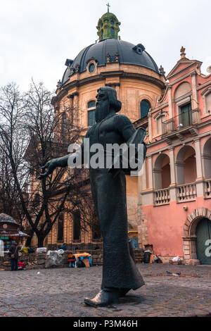 Statue von Ivan Fyodorov in Lemberg, Ukraine mit der dominikanische Kirche im Hintergrund. Stockfoto