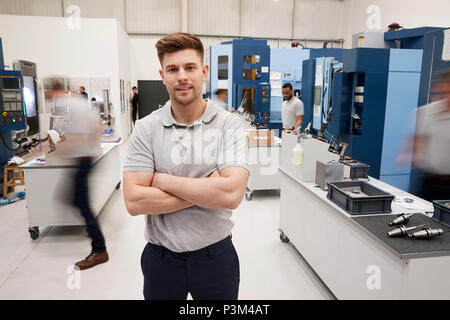 Portrait der männlichen Ingenieur auf Fabrikhalle des geschäftigen Workshop Stockfoto