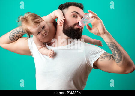 Vater halten und die Pflege von kleinen Säugling Baby, das Füttern aus der Flasche. Stockfoto