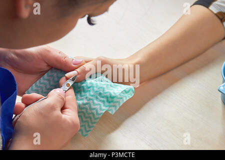 Weibliche Kosmetikerin schneiden Häutchen zu Client. Stockfoto