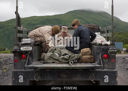 Petty Officer 3rd Class Jerry S. Pring (links), ein Krankenhaus Corpsman mit Loslösung B, Marine Wing Support Squadron-1541, Marine Flugzeuge Gruppe 49, 4 Marine Flugzeugflügel, Marine Reserve, Lance Cpl. David J. Rowe (Mitte), ein Flugzeug Rettung und Brandbekämpfung Spezialist mit Det. B, MWSS-472, Lance Cpl. Benjamin A. Bakker (rechts), ein Wartungstechniker mit Techniker Support Unternehmen, 6 Techniker, 4. Marine Logistics Group, simulieren Sie einen Unfall, Evakuierung auf innovative Readiness Training alter Hafen, Alaska, 9. Juli 2016. IRT Alten Hafen ist Teil einer Civ Stockfoto