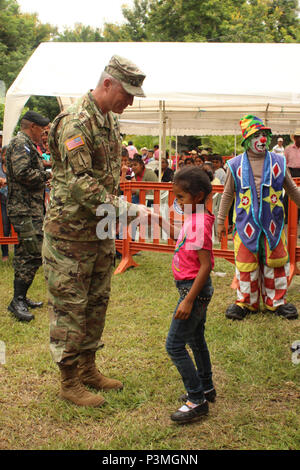 Us-Armee Oberst Brian Hughes, Kommandeur der Joint Task Force-Bravo, schüttelt Hände mit einem der Kinder, die eine medizinische Partnerschaft Engagement organisiert durch das Experimentelle Zentrum der landwirtschaftlichen Entwicklung und Naturschutz (CEDACE), in San Sebastian, Comayagua, 9. Juli 2016 besucht. JTF - Bravo nahmen an den MPE auf Antrag des Direktors des CEDACE und bot die Möglichkeit mit der lokalen Gemeinschaft zu engagieren und gleichzeitig Unterstützung der honduranischen militärischen Anstrengungen in der Betreuung für die lokale Bevölkerung. (U.S. Air Force Foto von Kapitän David Liapis) Stockfoto