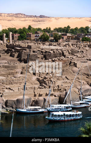 Boote segeln auf dem Nil, vorbei an den Ruinen von Abu auf Elephantine Island, Aswan, Ägypten. Stockfoto
