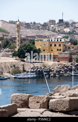 Blick auf das Westufer des Nils, mit einer Moschee, von den Ruinen von Abu auf die Insel Elephantine bei Assuan, Ägypten gesehen. Stockfoto