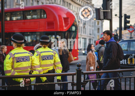 London, UK, November 2017. Zwei Polizisten patrouillieren und die Unterstützung der Menschen in Oxford Circus während der Weihnachtszeit. Querformat. Stockfoto