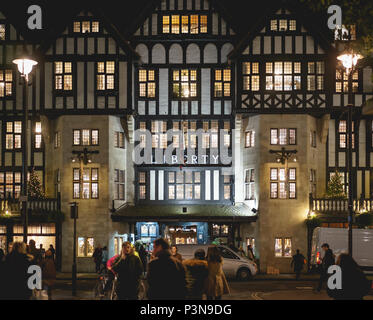 London, UK, November 2017. Die Menschen wandern vor der Liberty high class Kaufhaus in Soho in der Nacht während der Weihnachtszeit. Stockfoto