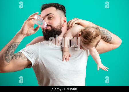 Vater halten und die Pflege von kleinen Säugling Baby, das Füttern aus der Flasche. Stockfoto