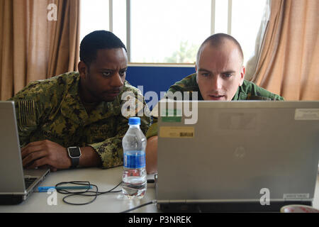 DAR-ES-SALAAM, Tansania - U.S. Navy Petty Officer 1st Class La Villa Marshall und Niederländische lt Rene Kleijer, Ost Accord 2016 Teilnehmer, die Aufgaben für den ersten Tag der kommandostellenübung an der tansanischen Peacekeeping Training Center, 19. Juli 2016, in Dar-es-Salaam, Tansania. EA 16 ist eine jährliche, kombiniert, gemeinsame militärische Übung, die zusammen bringt Partner Nationen zu Praxis und Kenntnisse in der Durchführung von friedenserhaltenden Maßnahmen zeigen. (U.S. Air Force Foto: Staff Sgt. Tiffany DeNault) Stockfoto