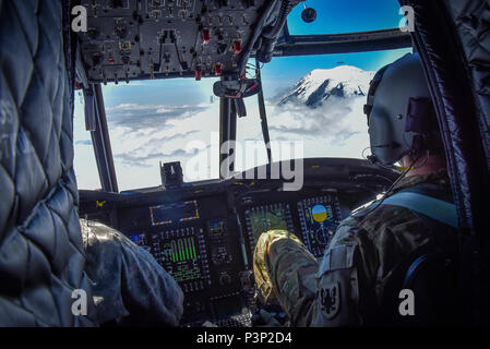 U.S. Army Reserve Chief Warrant Officer 3 Brian Pavlik, 1-214 th Allgemeine Unterstützung Aviation Battalion, Bravo Company, hält ein wachsames Auge während einer Überführung in der Nähe von Mount Rainier, Washington, an Bord eines CH-47 Chinook, 22. Juli 2016. Die 1-214 th GSAB, hat eine einzigartige Mission, gehört die Arbeit mit dem Washington National Park und bietet Unterstützung für die Such- und Rettungsaktionen sowie Fire Rescue Missionen in der Region. (U.S. Armee Foto von Master Sgt. Marisol Walker/Freigegeben) Stockfoto