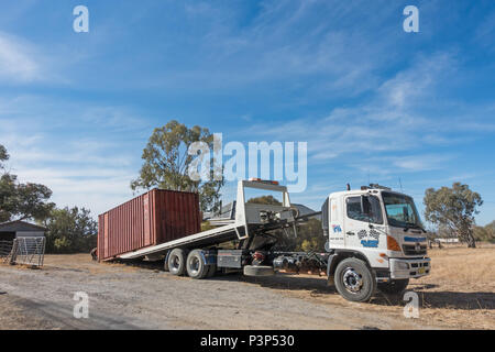 Eine alte Shipping Container auf einem Hino 500 Serie GH Kipper geladen wird. Stockfoto