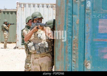 Ein peshmerga Soldat sichert einen offenen Bereich wie andere geben sie ein Gebäude während urban Operations Training am Manilla Training Bereich im Irak, 12. Juli 2016. Diese Schulung war Teil der modernen Brigade, welche Züge Soldaten auf die kleine Einheit militärischer Operationen, waffen, techniken und Abwehr selbstgebastelter Sprengladungen. Auszubildende sind auch mit neuen Geräten während des Kurses zur Verfügung gestellt, einschließlich Schutzkleidung und der M16 Gewehre. Die neue Ausrüstung und Ausbildung von Combined Joint Task Force - inhärenten Lösen hilft die irakischen Sicherheitskräfte in ihrer Mission, die Niederlage der Islami Stockfoto