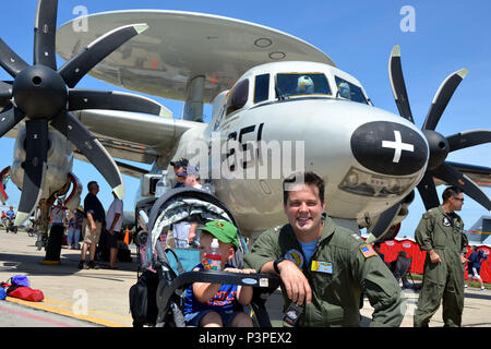 160723-N-WR 119-096 Sioux Falls, S.D. (Juli 23, 2016) E-2C Hawkeye Pilot, Lt Riley Schoeu, grayhawks von Carrier Airborne Early Warning Squadron (VAW) 120 zugeordnet sitzt neben einem Kleinkind an der Sioux Falls Air Show während Marine Woche in South Dakota. Von der Marine von Community Outreach (NAVCO), Marine Wochen gefördert werden eine Woche lang Zeitplan der Gemeinschaft übertreffen Engagements, dass die Amerikaner mit ihrer Marine anschließen, indem Navy Sailors, Ausrüstung und zeigt auf etwa 16 amerikanischen Städten, die nicht eine bedeutende Marine Gegenwart genießen. (U.S. Marine Foto von Massenkommunikation Specialis Stockfoto