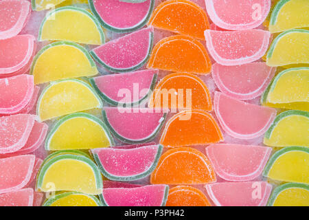 Gelee-marmelade Bonbons in verschiedenen Farben in Form von Zitrusfrüchten Wassermelone Keile. Lebendige bunte Palette Orange Gelb Grün Rot Rosa. Patter Stockfoto