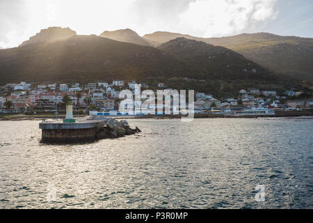 Landschaft Blick auf den Eingang zum Hafen und steuerbord Rundumleuchte gegen den Hintergrund der Berge mit Häuser am Berghang in Kalk Bay Cape Peninsula Stockfoto