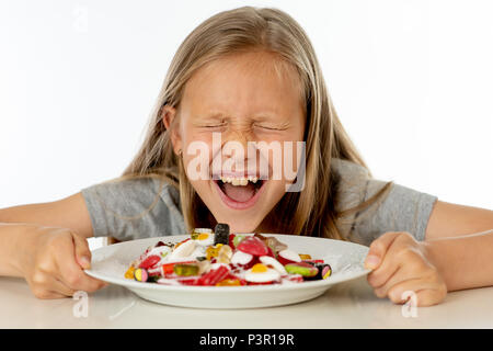 Recht glücklich Zucker hoch kaukasischen weibliches Kind essen Teller voller Süßigkeiten mit Messer und Gabel in süßen Zucker Missbrauch gefährlich Ernährung und ungesunde Nutr Stockfoto