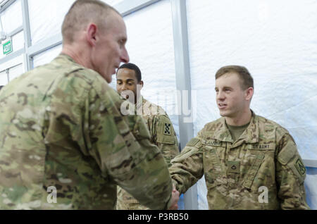 Generalmajor Gary J. Volesky, Kommandeur der Combined Joint Forces Land Component Command-Betrieb inhärenten Lösen und Luftlandedivision (Air Assault), präsentiert Pfc. Bradley Lanning, ein Soldat mit Charlie Company, im Air Defense Artillery, mit einem Commander Münze an Life Support Bereich Gefahr, in der Nähe von Erbil, Irak, 23. Juli 2016. Life Support Bereich Gefahr bietet Unterkunft, Nahrung, Wasser und andere Grundlagen zu US-Soldaten und andere Mitglieder, die in den Norden des Irak zur Unterstützung der Operation inhärenten Lösen bereitgestellt werden. (U.S. Armee Foto: Staff Sgt. Peter J. Berardi) Stockfoto