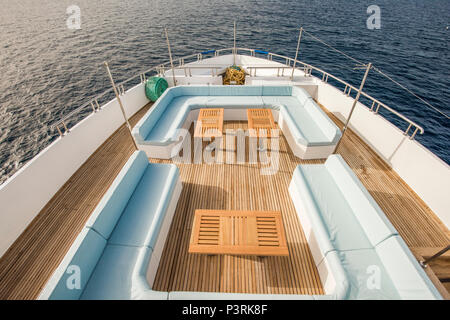 Bug Teak Deck eines großen luxuriösen Motoryacht mit Stühlen, Couchtisch und Tropischen Meerblick Hintergrund Stockfoto